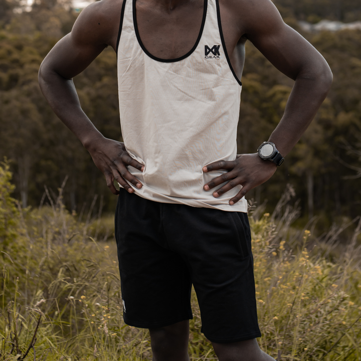 IXK Gear Cotton Stretch Shorts in Black. Model is also wearing IXK Gear Stringer Tank Top in Stone. Natural background.