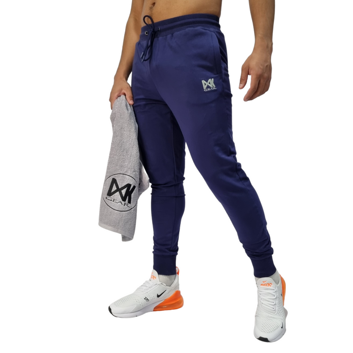 Pictured on model IXK Gear Slim Sweat Trackpant Trackies in Colour: Blue. Model is holding the IXK Gear Gym Towel in Grey. Plain White Background.