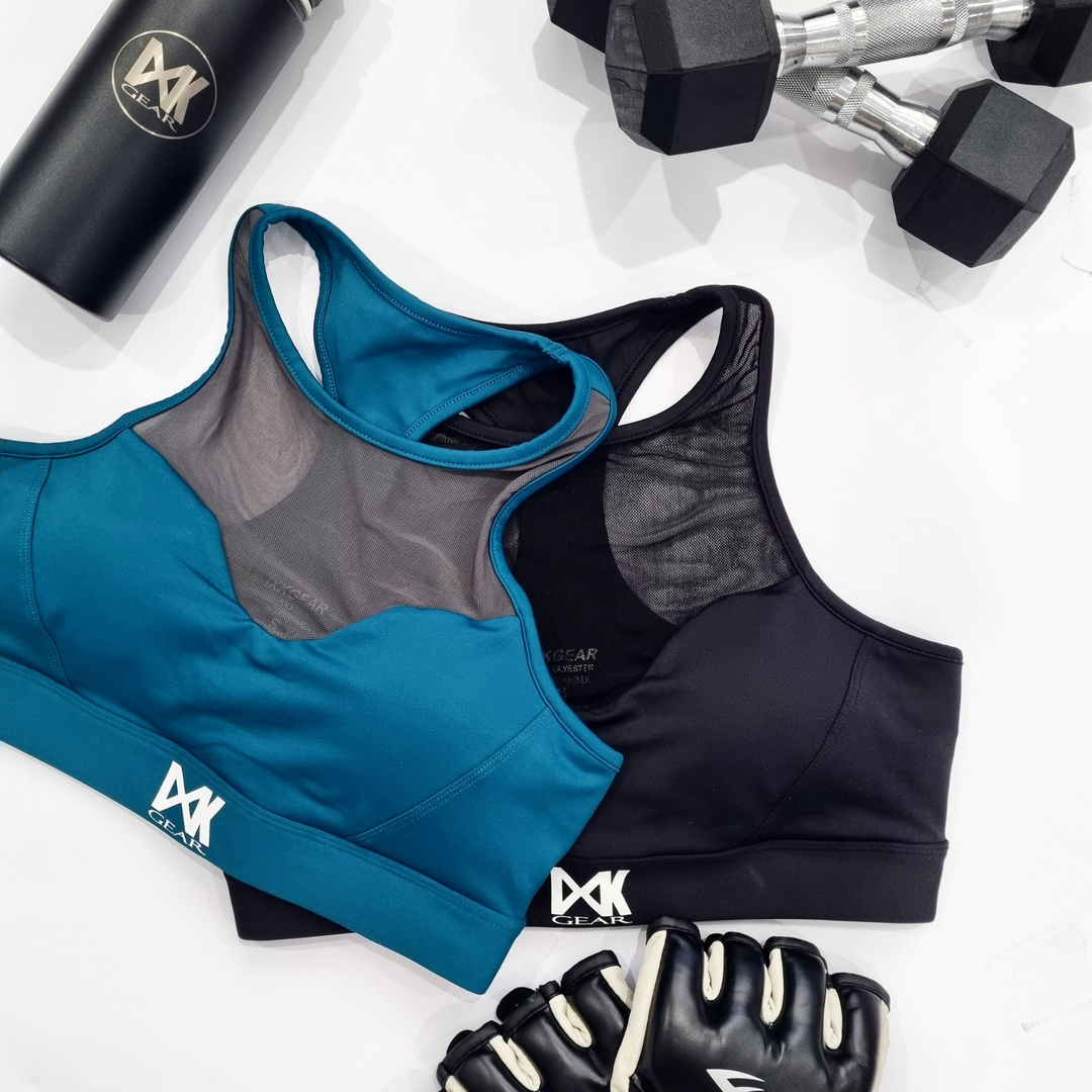 Flat lay of IXK Gear Mesh Sports Bra in Black and Teal. Plain white background.