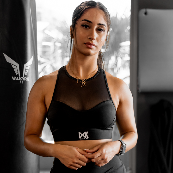 IXK Gear Mesh Sports Bra in Colour: Black paired with NV Tights in Black. Gym Background.