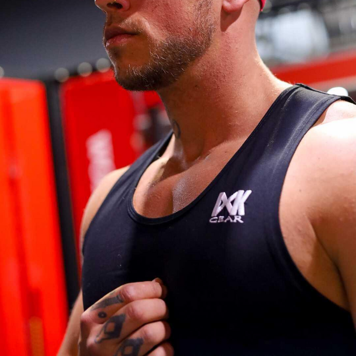 IXK Gear Muscle Tank Top in Black. Gym background.