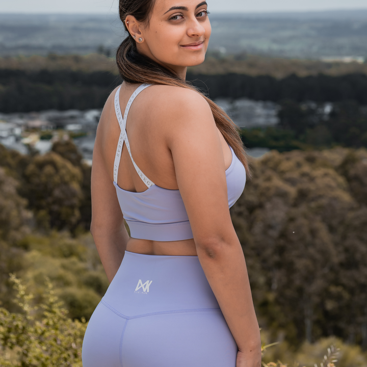 IXK Gear X Sports Bra in Colour: Lavender. Natural Background. Model is also wearing NV Tights in Colour: Lavender.